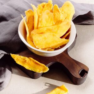 Home Bright and tasty homemade mango chips in a bowl, perfect for a healthy snack.